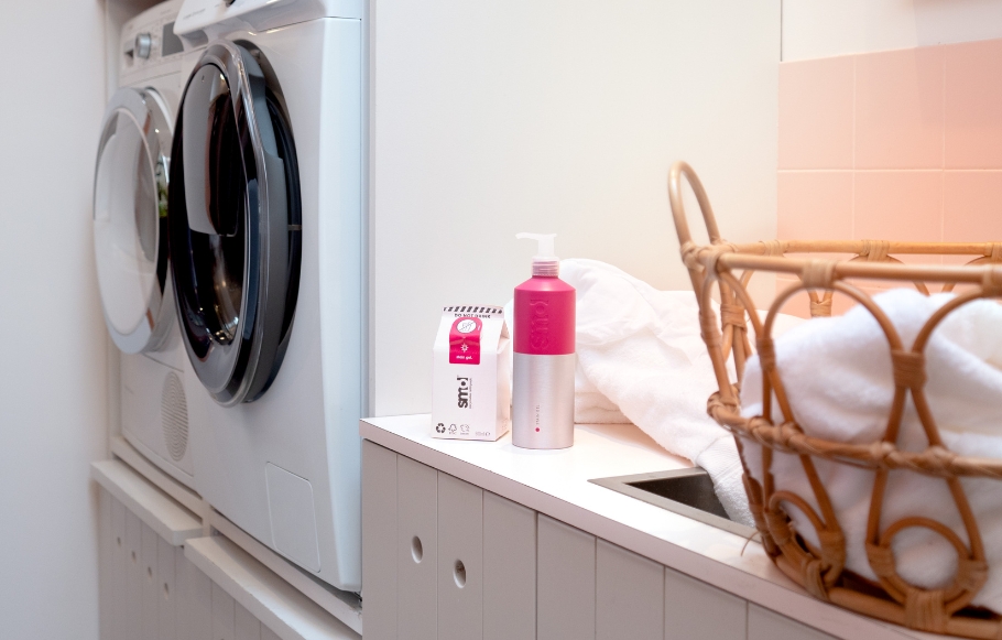 smol stain gel in aluminium bottle sits on countertop next to washing machines