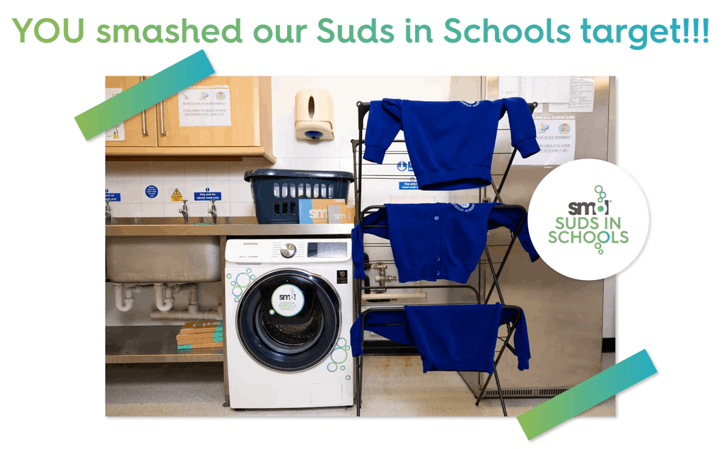 washing machine in a school, with school jumpers drying on a rack next to it. text: you smashed our suds in schools target!!!