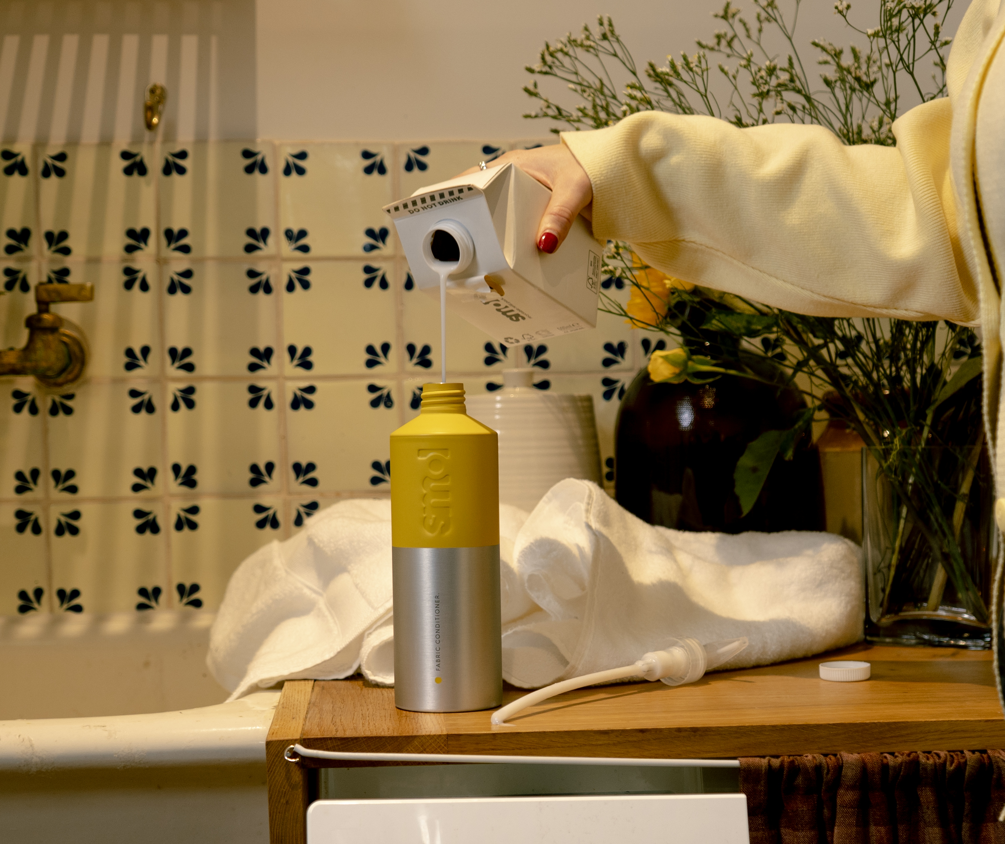 smol fabric conditioner refill carton being poured into a smol aluminium bottle-for-life
