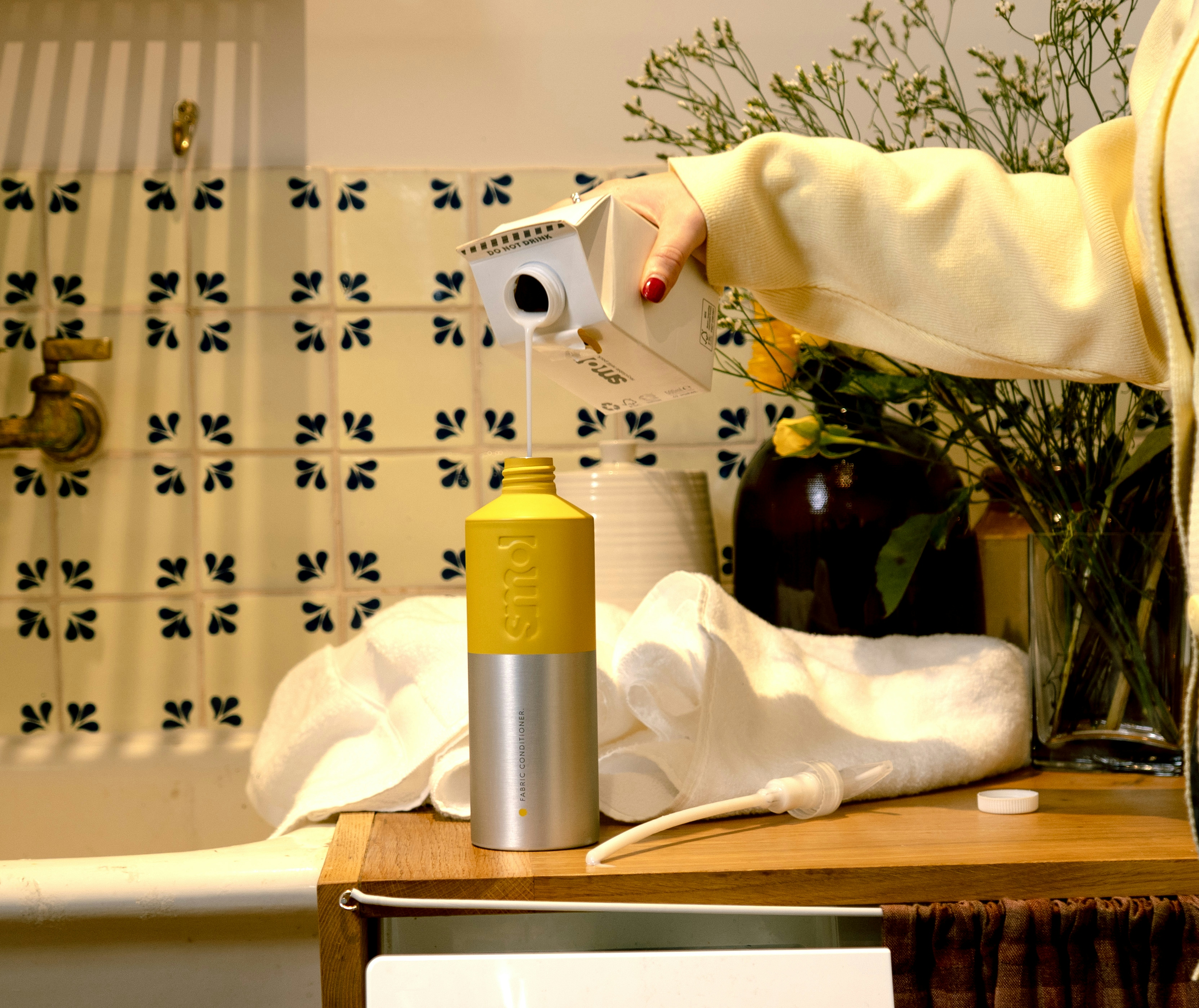 smol fabric conditioner refill carton being poured into a smol aluminium bottle-for-life