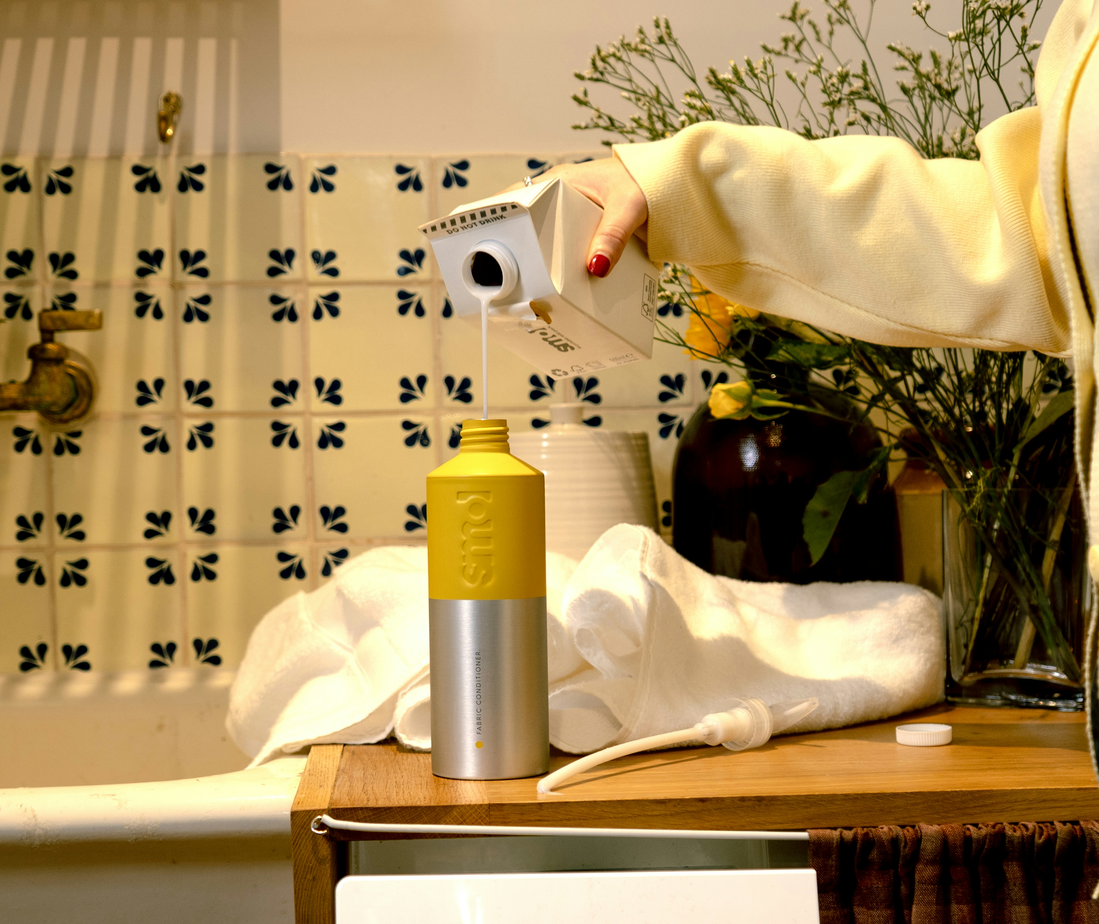 smol fabric conditioner refill carton being poured into a smol aluminium bottle-for-life