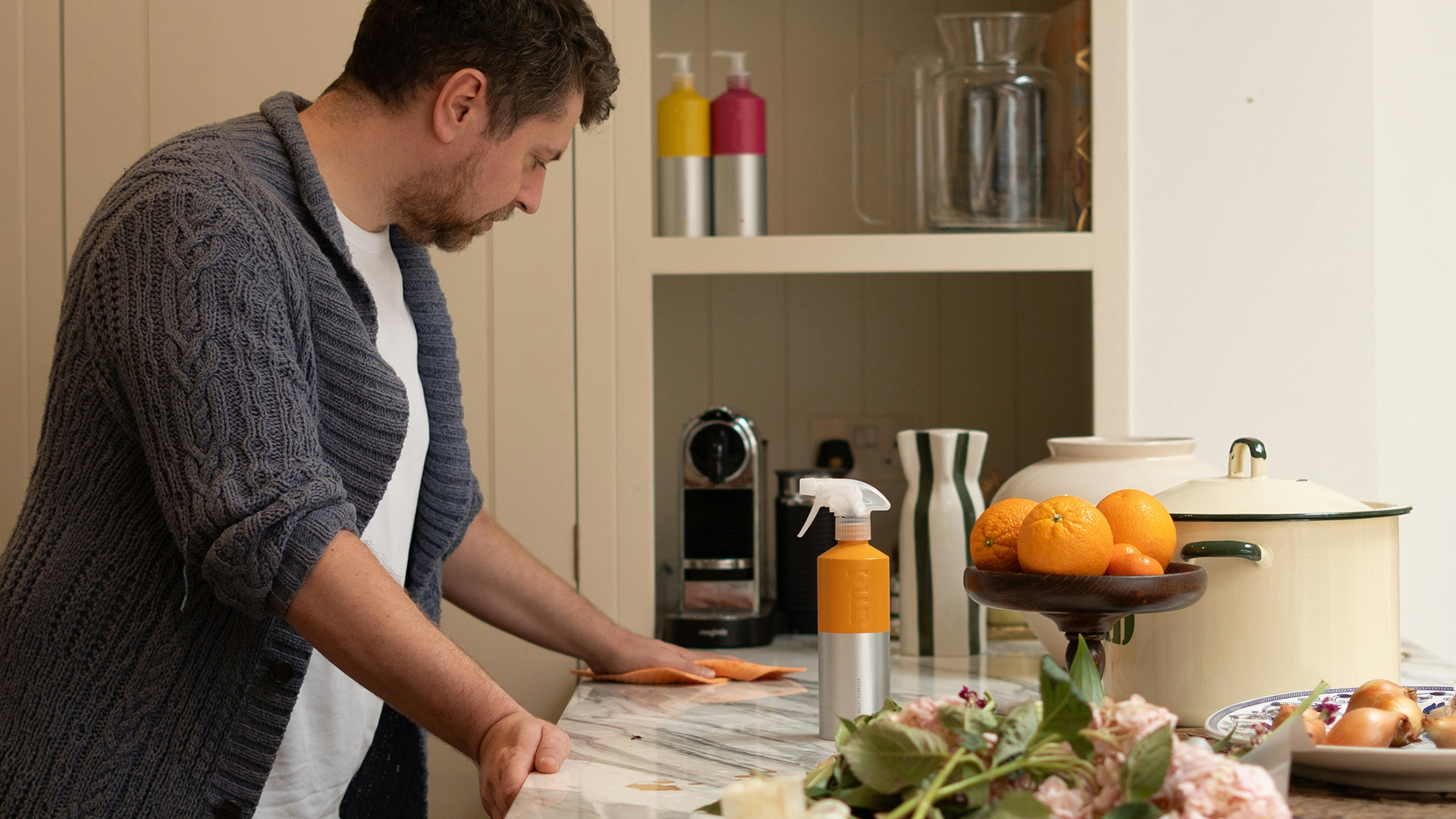 man cleaning a kitchen countertop using smol multi purpose spray