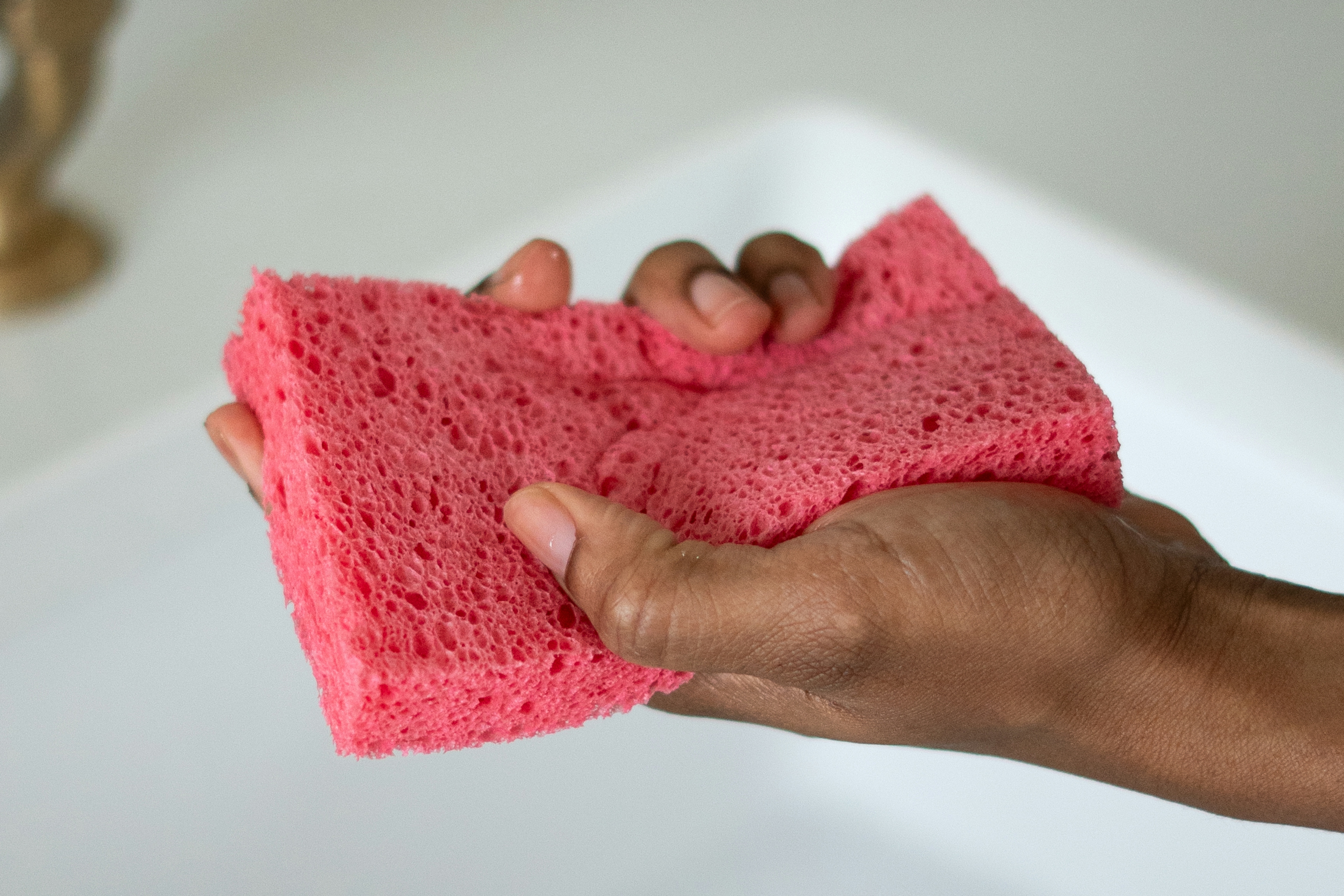 close-up image of hand holding pink sponge