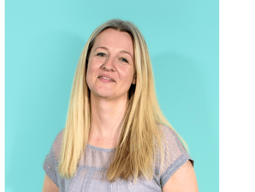 catherine green, a woman with long blonde hair is looking at the camera smiling against a blue green background