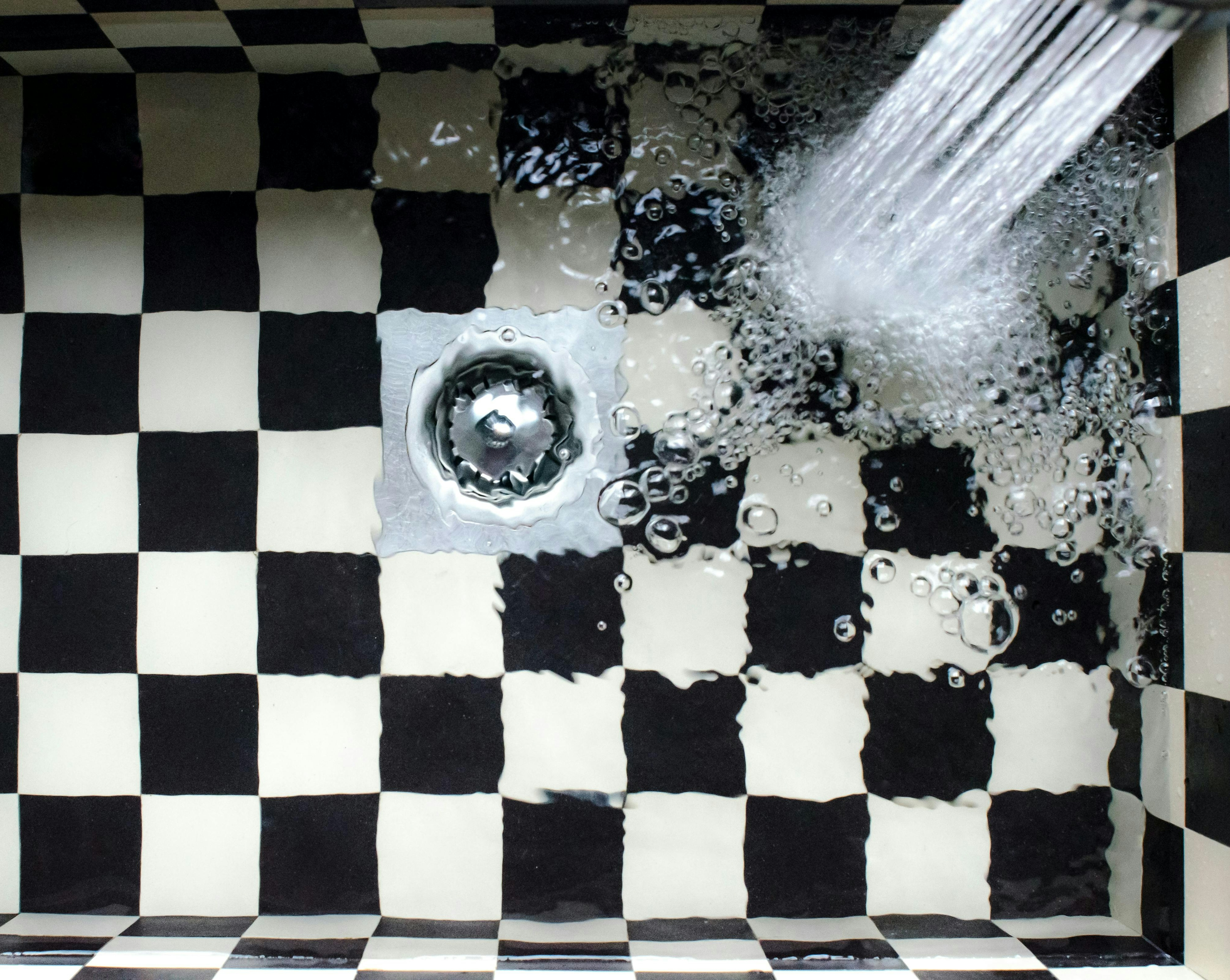 water in black and white checkered sink