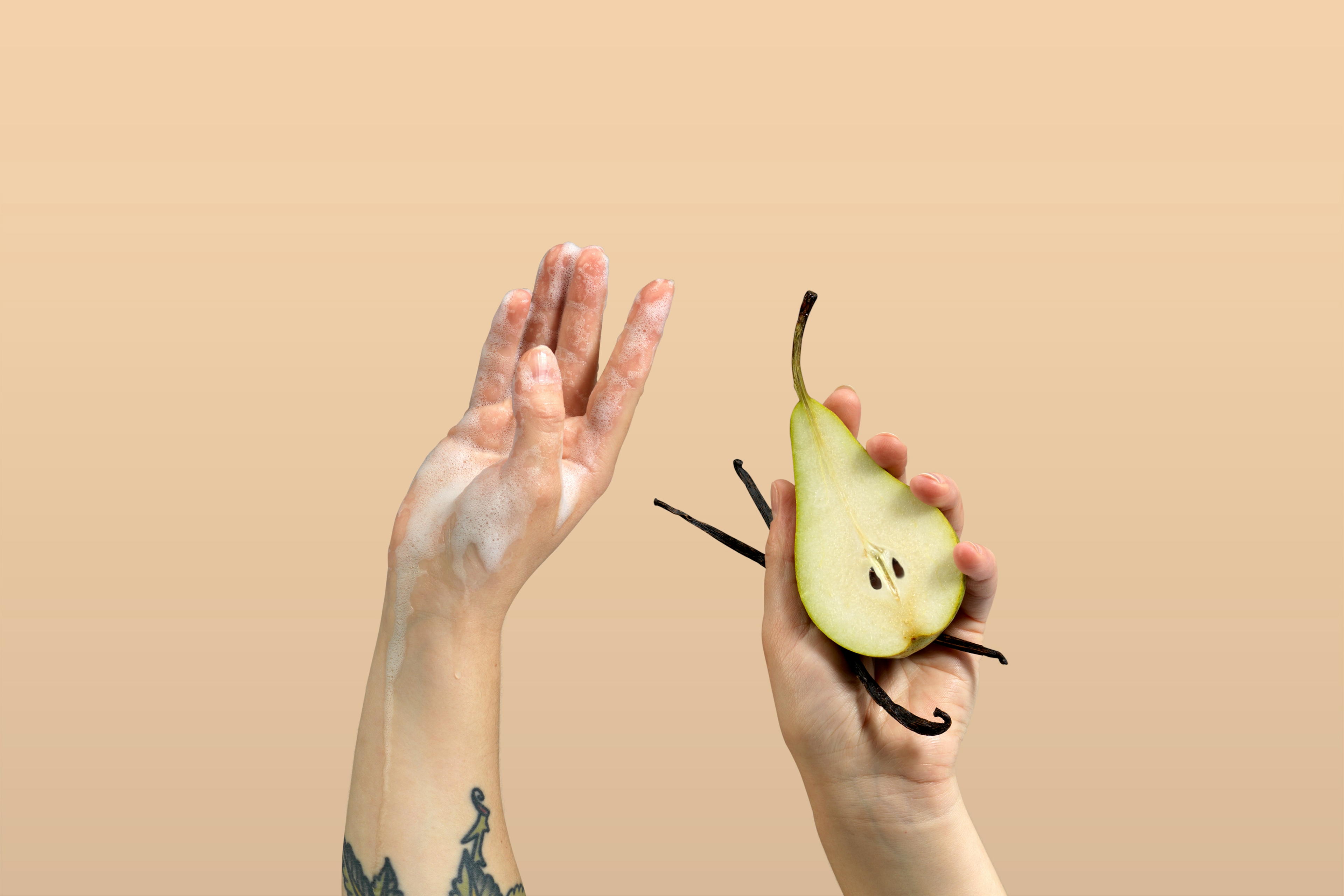 Set of hands up in the air, one hand covered in foam the other holding half a pear and vanilla pods