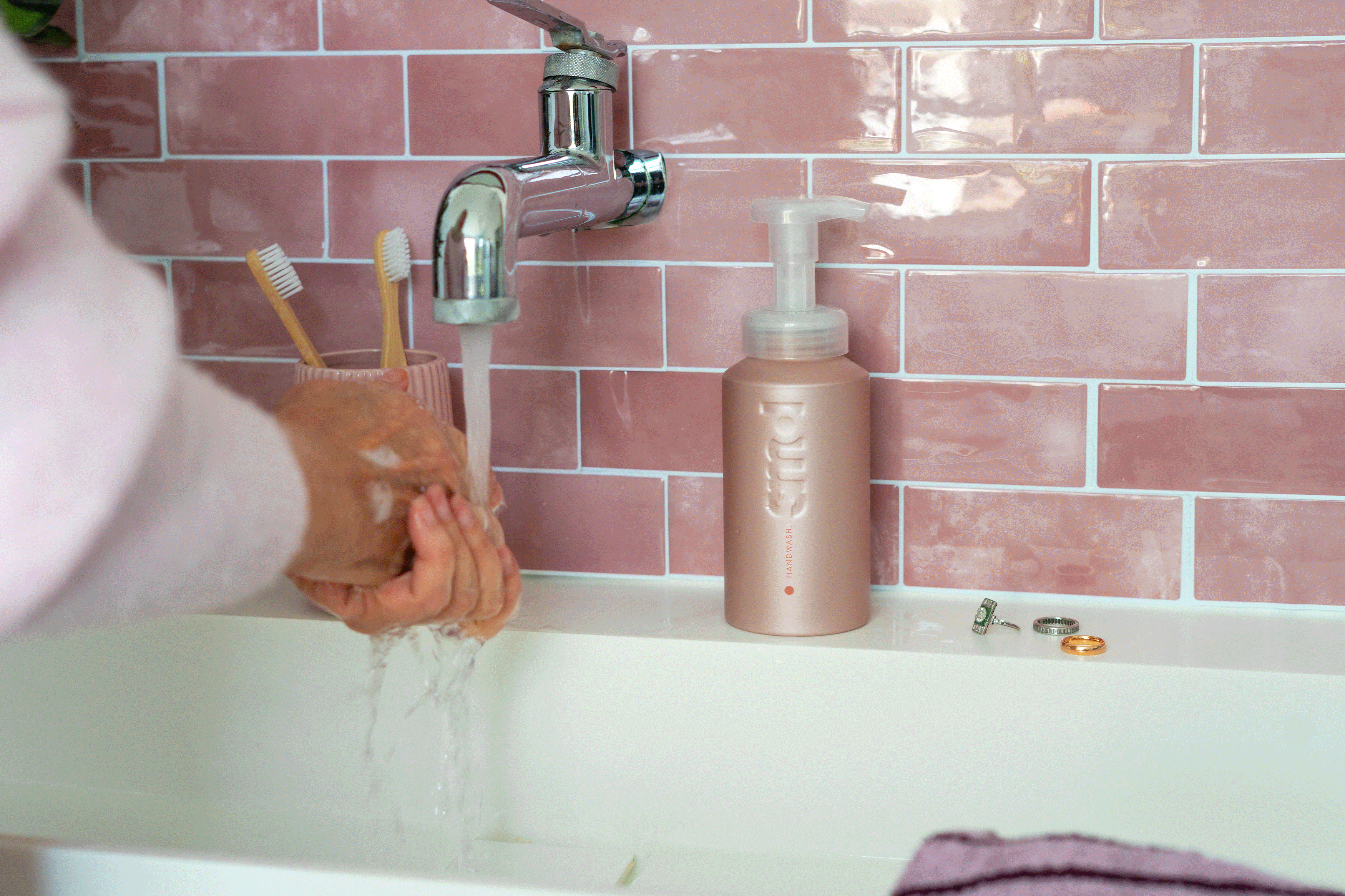 GIF of hands applying foaming handwash at sinks in multiple bathroom