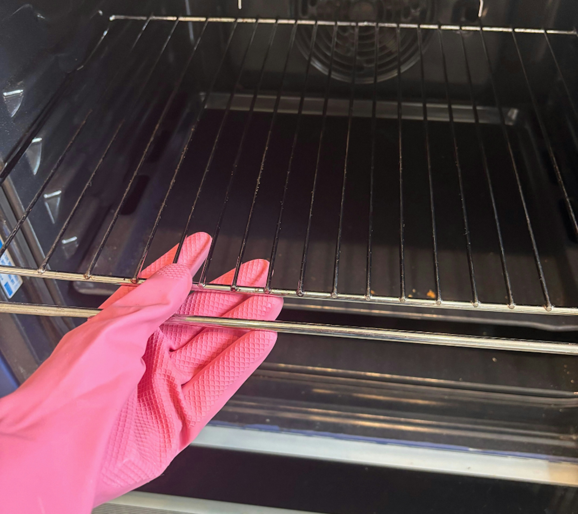 hands wearing smol rubber gloves taking oven shelves from oven