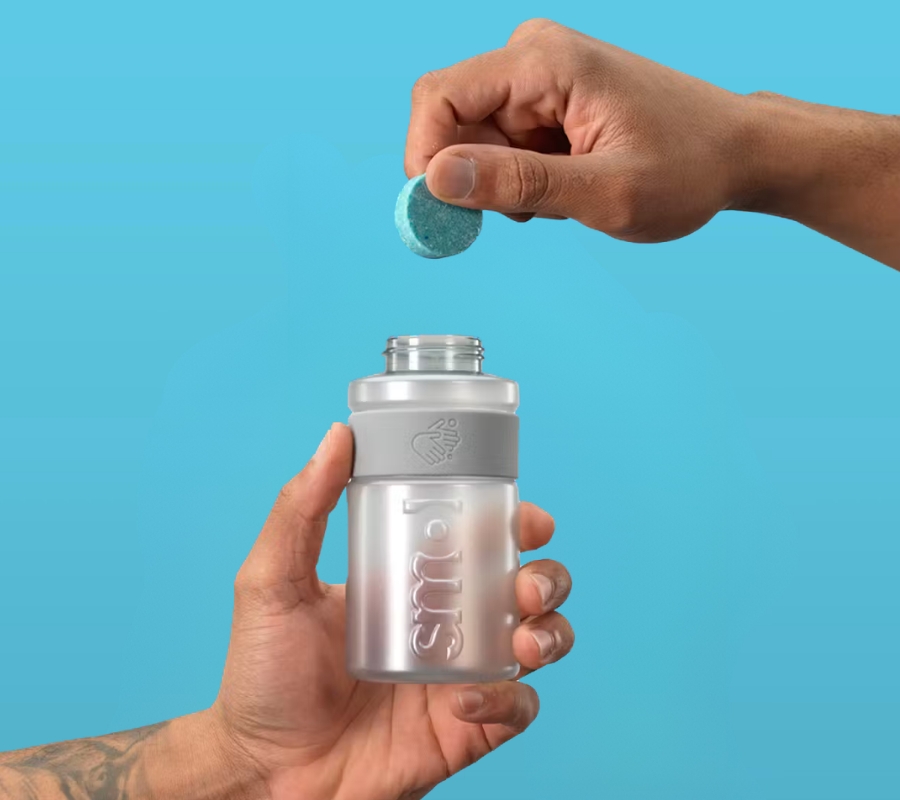 hands holding open smol handwash bottle and refill tablet