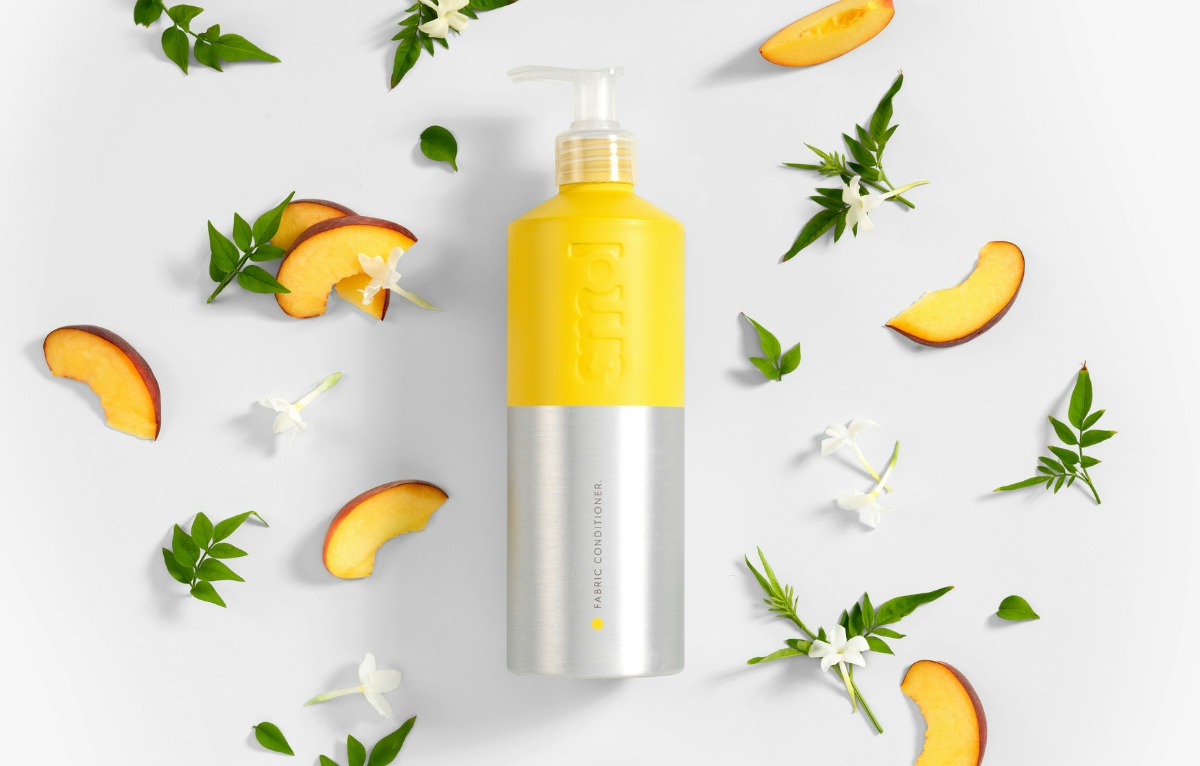 fabcon in aluminium bottle surrounded by peaches and jasmine