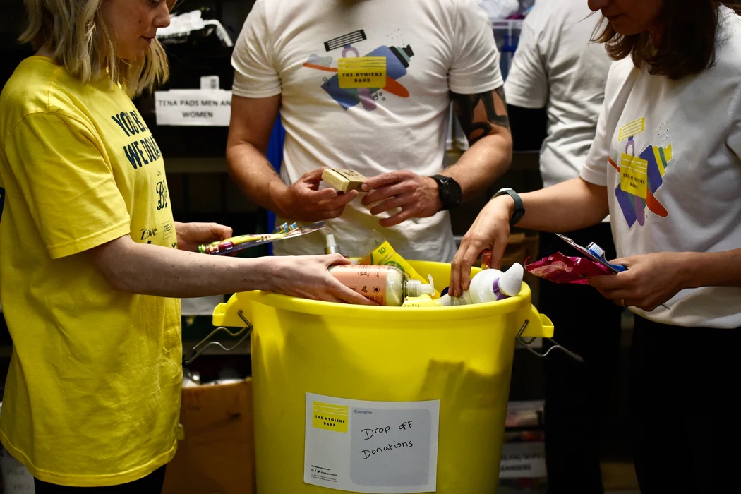 a group of hygiene bank volunteers sorting through a bucket of hygiene products