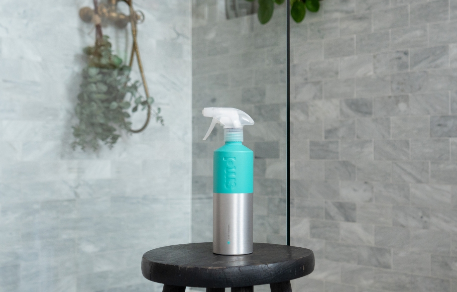 smol bathroom cleaner in aluminium bottle on a stool in a shower
