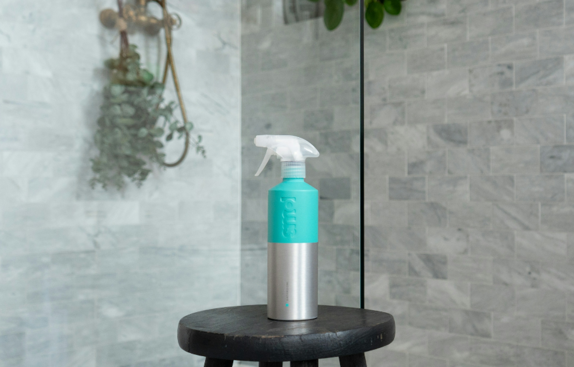 smol bathroom cleaner in aluminium bottle on a stool in a shower
