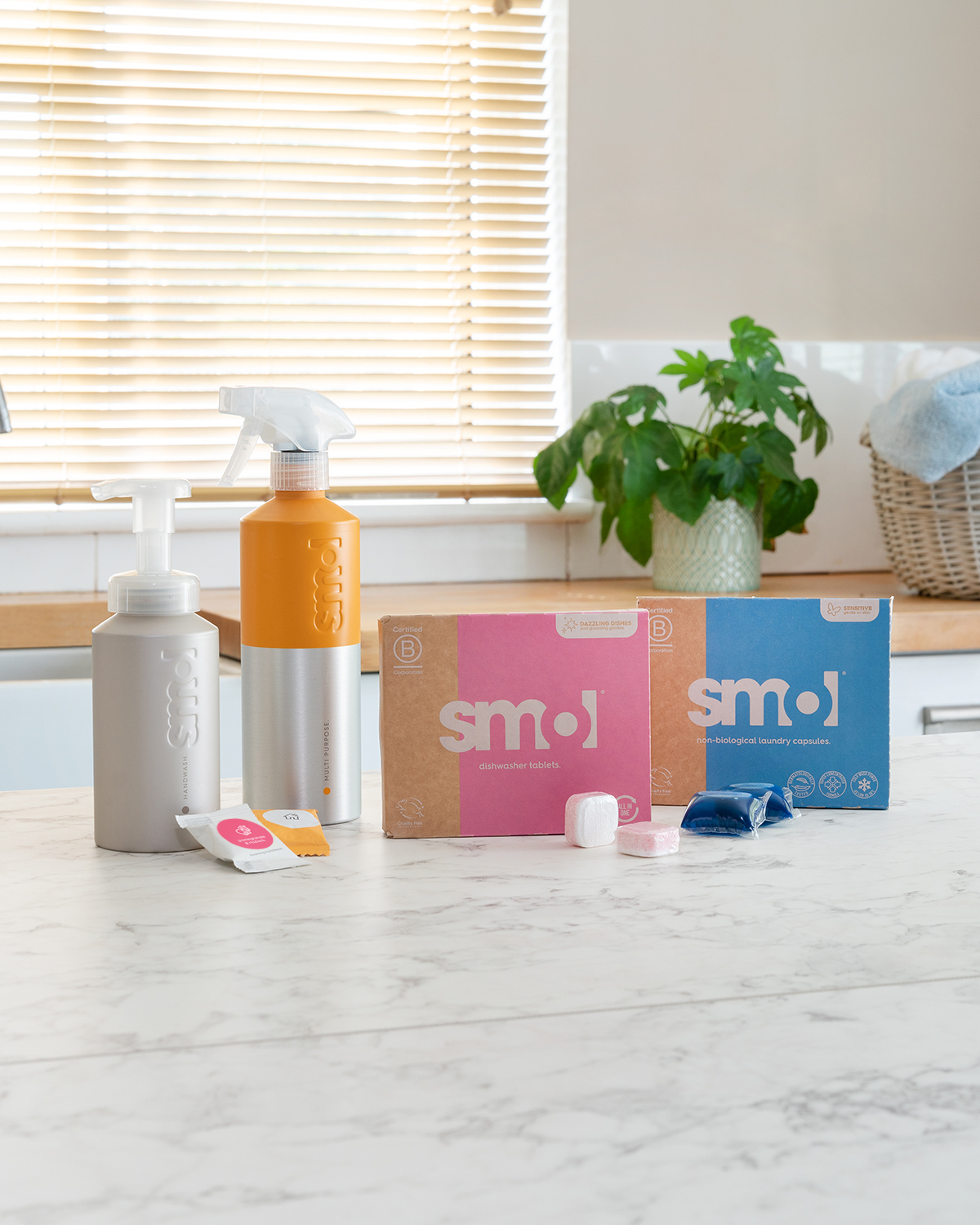 smol foaming handwash, multi purpose spray, dishwasher tablets and laundry capsules on a kitchen counter